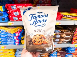 Hand holding a seven-ounce package of Famous Amos Cookies at Walmart