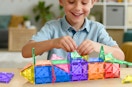 a kid playing with colorful magnetic tiles
