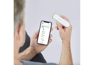 holding a thermometer by a phone