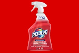 a spray bottle of carpet cleaner on a red background