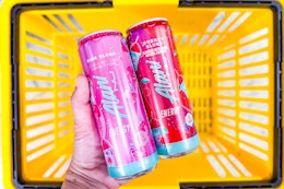 hand holding alani nu energy drinks above a yellow basket