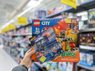 hand holding lego and nerf toys