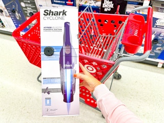 hand holding a shark cyclone vacuum in front of target cart