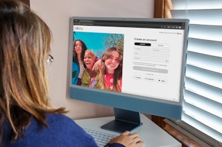 A person looking at three people smiling on a computer screen.