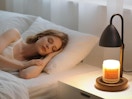 a person sleeping a bed next to a candle warmer lamp