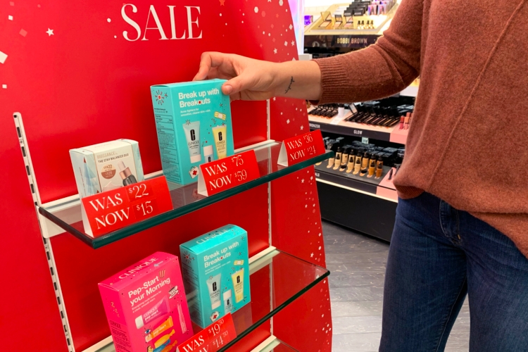 A person reaching to take a product from a sale shelf in Sephora.