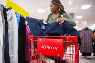Person shopping with a red JC Penney's cart
