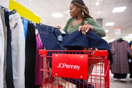 Person shopping with a red JC Penney's cart