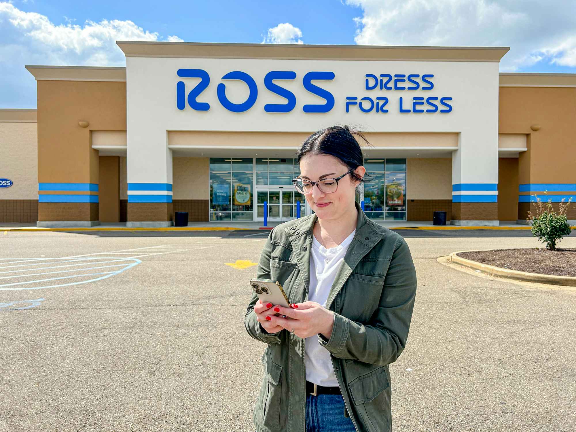 a person looking at their phone outside of a ross
