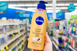 person holding a bottle of nivea lotion in an aisle