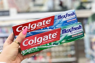 hand holding two tubes of toothpaste