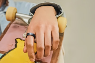 Lifestyle image of a close up shot of a hand over a skatboard with the Samsung Galaxy Ring on pointer finger