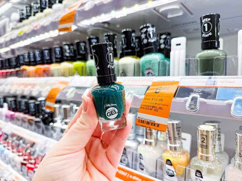 person holding a bottle of nail polish by the display