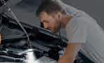 a person fixing a car with a magnetic pickup tool