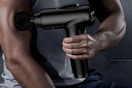 Man using a Deep Tissue Massage Gun on his arm.