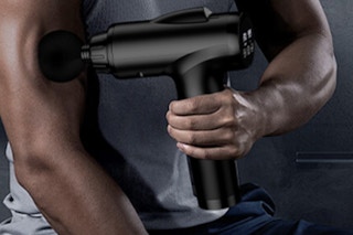 Man using a Deep Tissue Massage Gun on his arm.