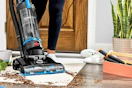 Bissell PowerForce Helix being used to clean up dirt off the floor 