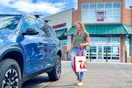 a woman walking to her car with a walgreens bag 