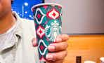 a person holding a startbucks holiday drink
