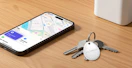 an air tracker on a pair of keys next to a phone showing a map