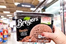 hand holding a tub of breyers ice cream