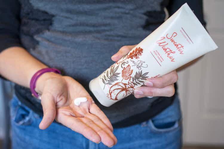 A woman squeezing lotion from a bottle