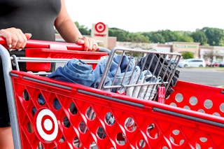 a person pushing a cart full of jeans at target 