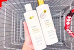 person holding 2 bottles of dove shampoo over a cart