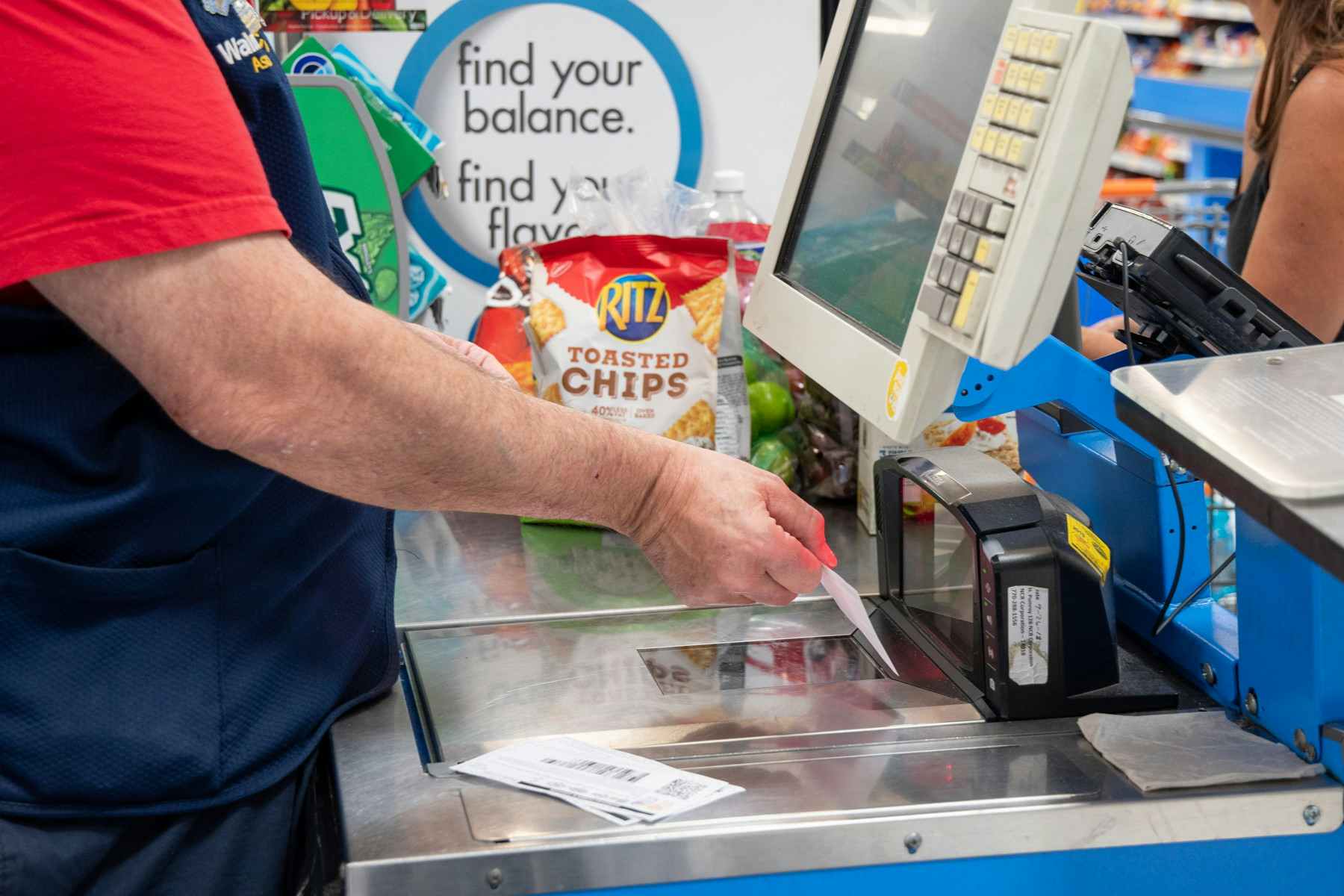 A Walmart cashier scanning a coupon at a register.
