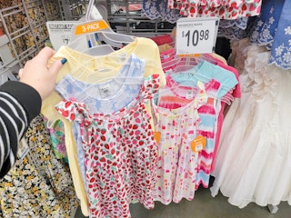 hand holding a set of 3 kids dresses