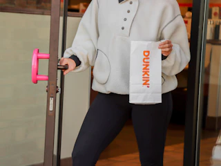 a person exiting dunkin donuts