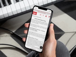 a person looking at their cell phone at the guitar center return policy