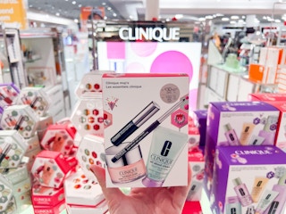 someone holding a clinique small makeup gift set