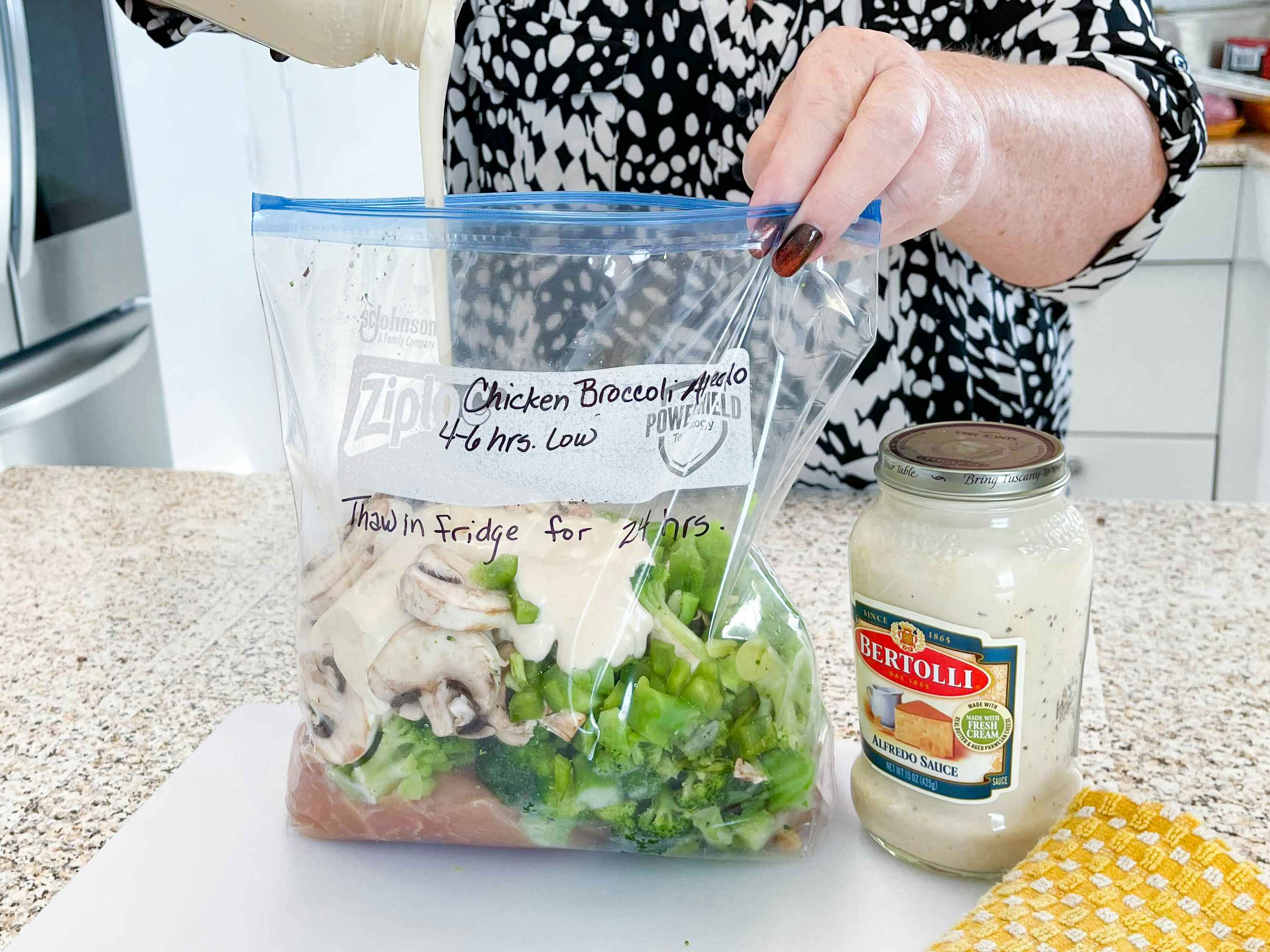 a person adding in ingredients into a freezer bag meal