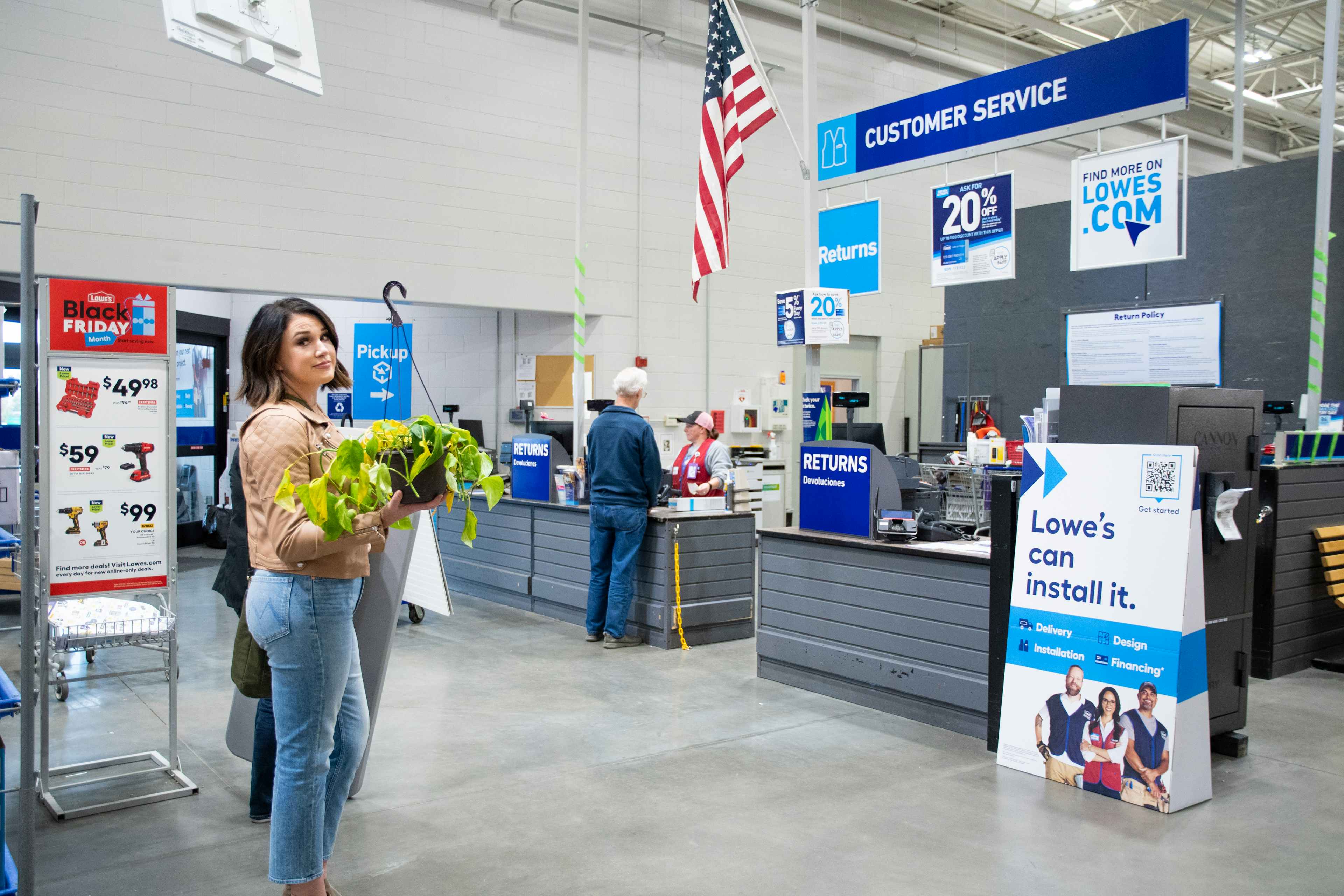 a woman standing in line at Lowe's waiting to return her dead plant