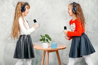 two girls singing with a Mini Karaoke Machine