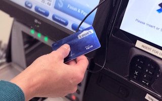 someone next to a lowes credit card at checkout