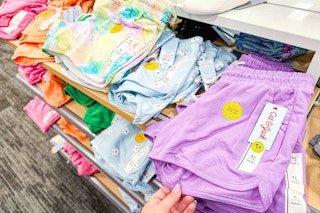 hand grabbing a cat & jack kids shorts off a target shelf