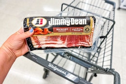 person holding a package of jimmy dean bacon over a walgreens cart