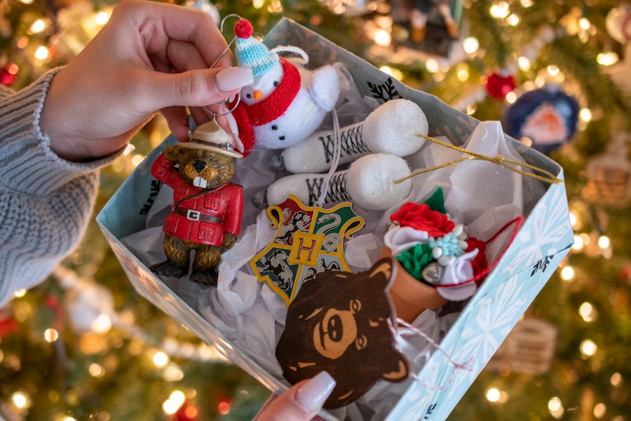 A person pulling an ornament out of a box of other ornaments.