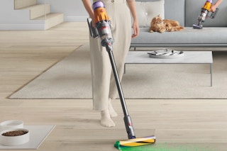a woman vacuuming her floor with a Dyson V12 Detect Plus Slim Vacuum with 7 Attachments