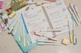 a open notebook with colorful highlighters on top 