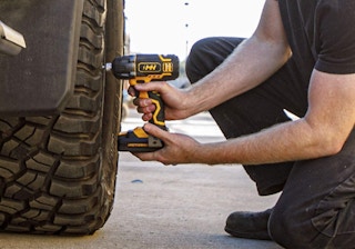 a person using a drill on a tire