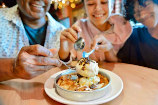 Three people digging their spoons into a Pizookie from BJ's Restaurant and Brewhouse