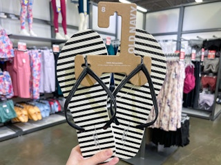 hand holding up a pair of striped flip flops