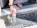 a person grabbing a newspaper from porch