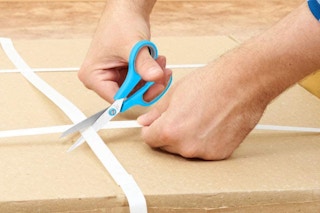 a person cutting open a box