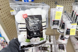 person holding a bag of cotton balls