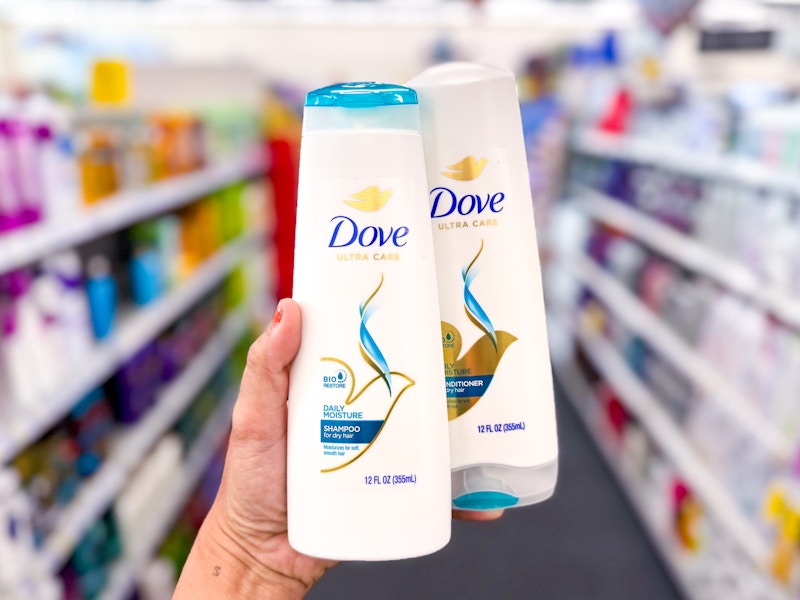hand holding a Dove shampoo and conditioner bottle