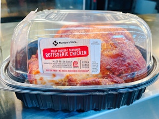 A boxed Member's Mark rotisserie chicken sitting on a shelf inside Sam's Club.